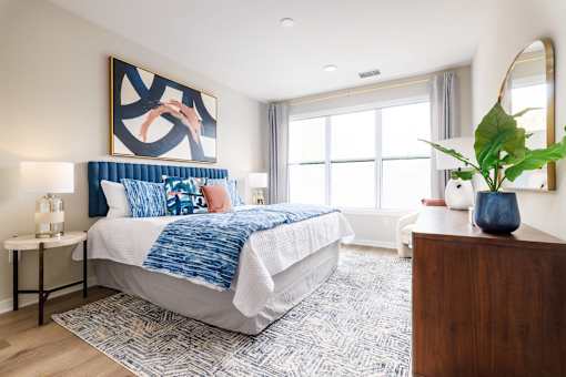 A bedroom with a large bed and a painting on the wall.