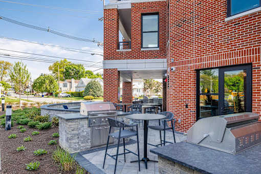 A red brick building with a patio and outdoor furniture.