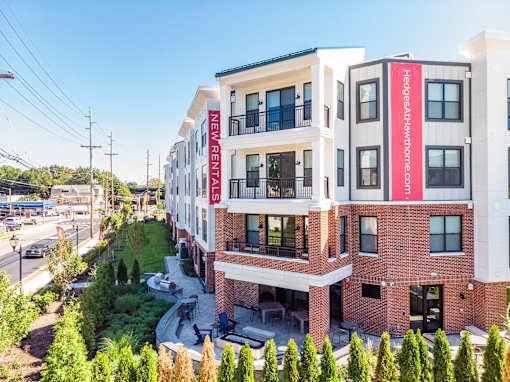 A multi-story building with a red and white sign that says New Rentals.