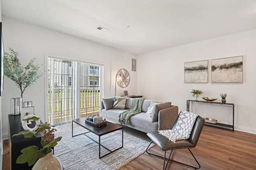 A living room with a grey couch, a black chair, and a coffee table.