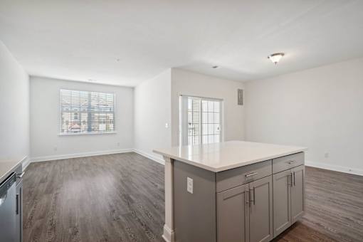 A kitchen with a refrigerator, cabinets, and a countertop is shown.