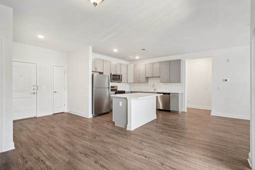 A kitchen with a white island and stainless steel appliances.