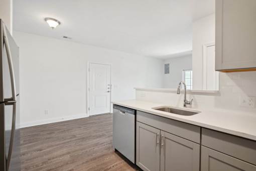 A kitchen with a white counter top and a dishwasher.