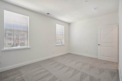 A room with a carpeted floor and a door.