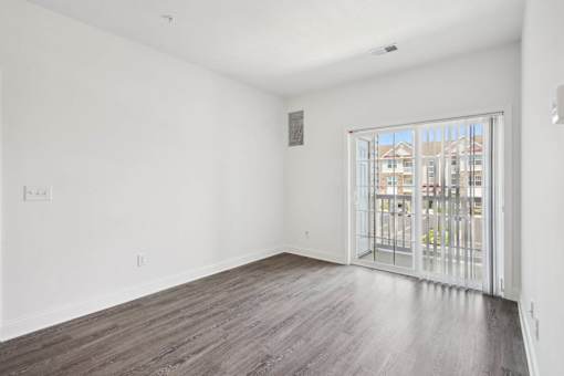 A room with a sliding glass door leading to a balcony.