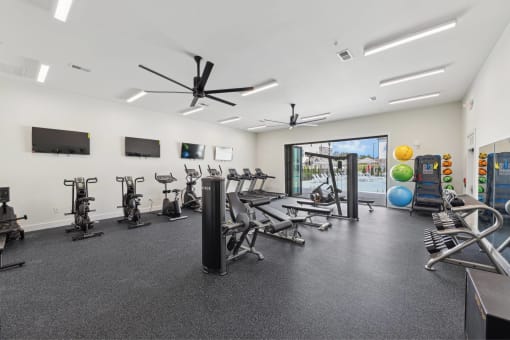 a gym with treadmills and other exercise equipment in a building with a window