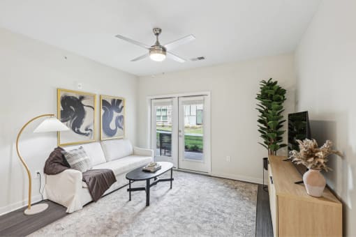 a living room with a white couch and a ceiling fan
