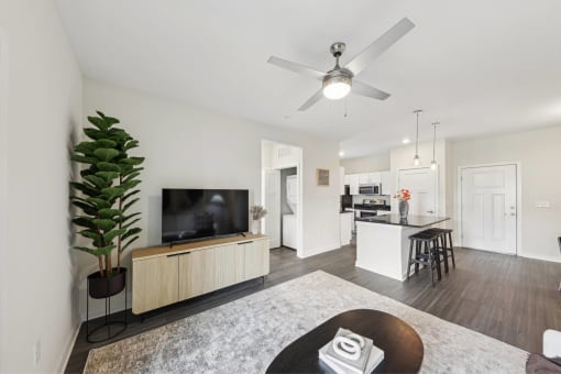 a living room and kitchen with a ceiling fan
