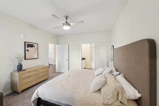 a bedroom with a large bed and a ceiling fan