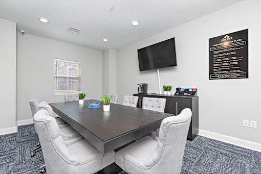 A conference room with a long table and chairs.
