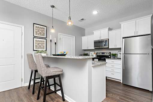 A kitchen with a white counter and stainless steel appliances.