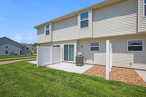 A house with a grey siding and a white fence.