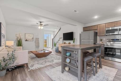 A modern kitchen with a wooden island and stools.