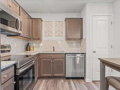 A kitchen with brown cabinets and a white door.