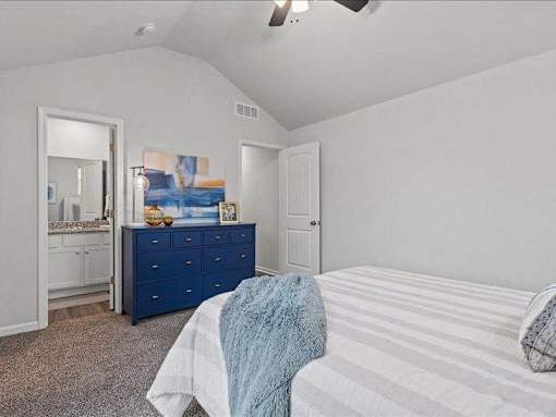 A bedroom with a bed, dresser, and mirror.