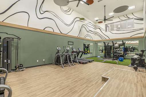 A gym with a green wall and wooden floor.
