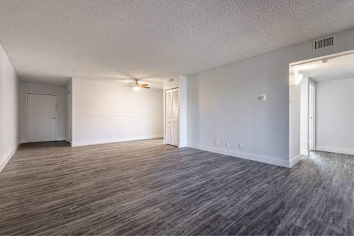 A room with wooden flooring and white walls.