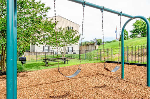 A playground with a swing set and a slide.