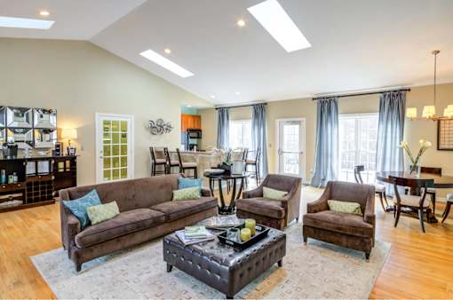 A living room with a brown couch, two chairs, and a coffee table.