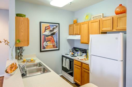 A kitchen with a white fridge, a sink and a microwave.