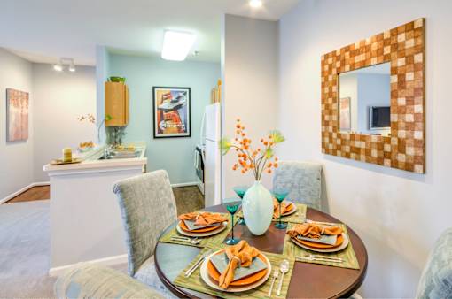 A dining room with a table set for a meal.