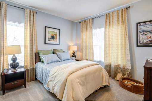 A bedroom with a large bed and a painting on the wall.