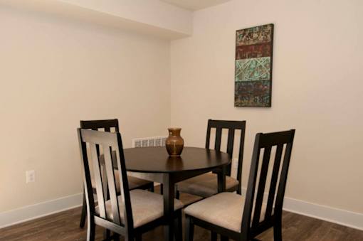 A dining room with a table and chairs.