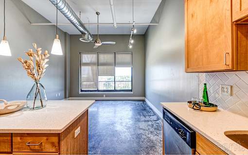 A kitchen with wooden cabinets and a concrete floor.