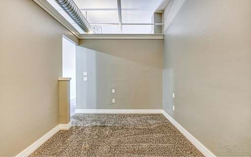 A room with a carpeted floor and a window.