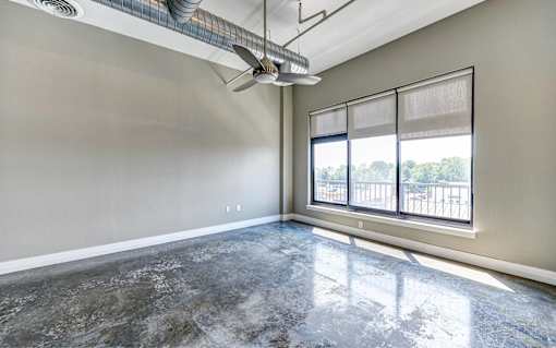 A room with a marble floor and a window overlooking a balcony.