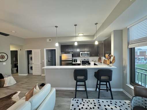 A modern kitchen with a bar area and a dining table.