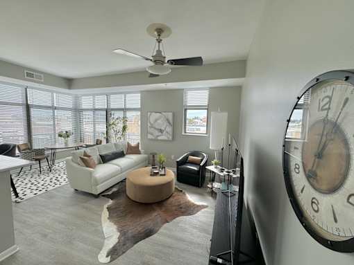 A living room with a large clock on the wall.