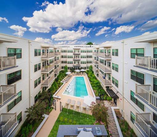 Silver Spring, MD Pet Friendly Apartments - Atelier Apartments - Exterior Shot Of Swimming Pool Surrounded By Lounge Chairs And Umbrellas