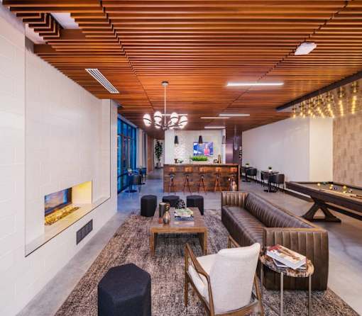 A modern living room with a pool table and a fireplace.