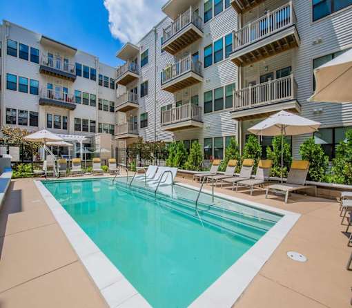 A large swimming pool in front of apartment buildings.