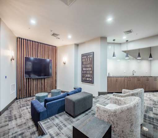 A living room with a flat screen TV and a carpeted floor.