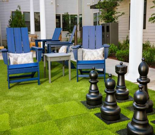 A set of chess pieces are set up on a lawn.
