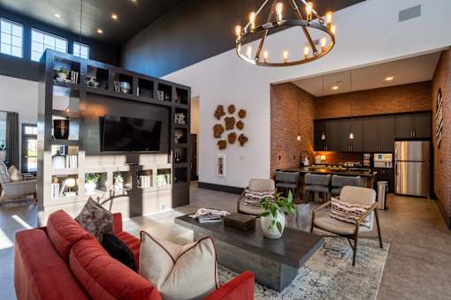 A living room with a red couch and a chandelier.