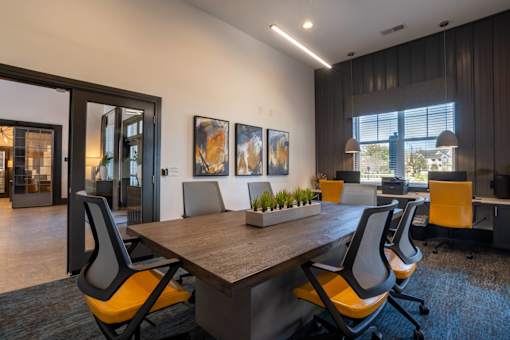 A conference room with a long table and chairs.