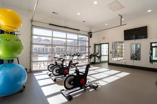 A gym with exercise equipment and a television.