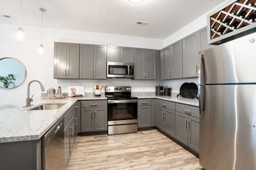 A modern kitchen with stainless steel appliances and wooden floors.