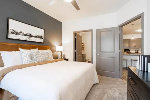 A bedroom with a large bed and a painting on the wall.