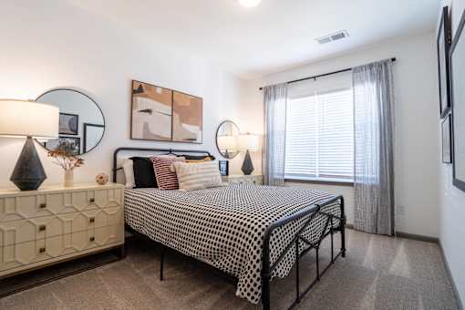 A bedroom with a bed, nightstand, and two lamps.