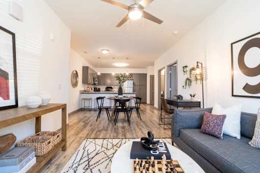 A living room with a grey couch, a coffee table, and a ceiling fan.