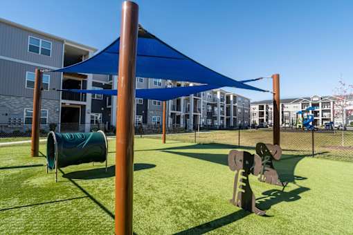 A playground with a blue canopy and a green slide.