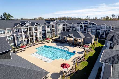 A large swimming pool surrounded by apartment buildings.