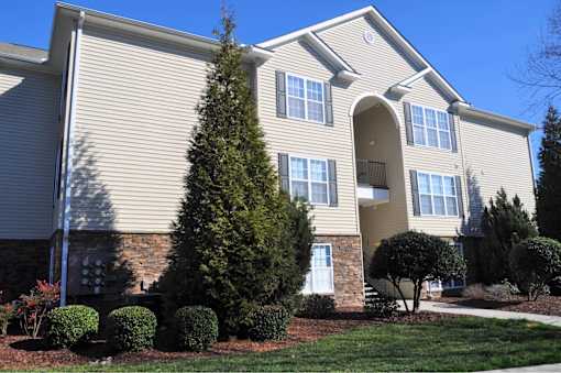 A beige house with a white door and windows.