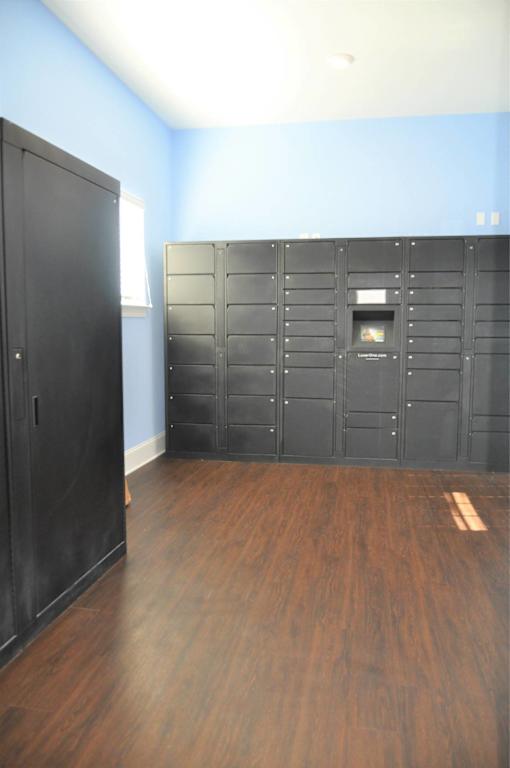 A room with a black cupboard and a wooden floor.