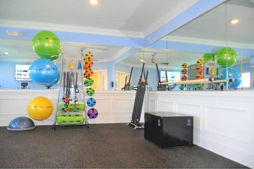 A room with exercise equipment and a mirror.
