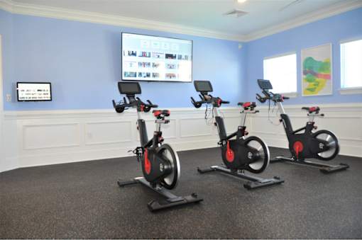 Three stationary bikes are lined up in a room.